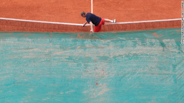 A court attendant covers the center court as rain falls over the Roland Garros stadium on June 6. The rain interrupted the semifinal match between Maria Sharapova and Victoria Azarenka.