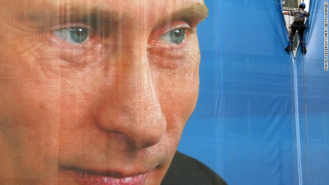 A worker takes down a giant elections poster bearing a portrait of Putin on October 13, 2009, in Moscow. Putin's party tightened its grip on Russian politics with a sweeping victory in local elections, officials said, as the opposition alleged widespread fraud.