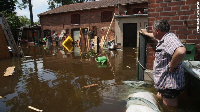 A resident wades to a neighbor's house on a flooded street near the swollen Elbe River on Friday, June 7, in Elster, Germany.