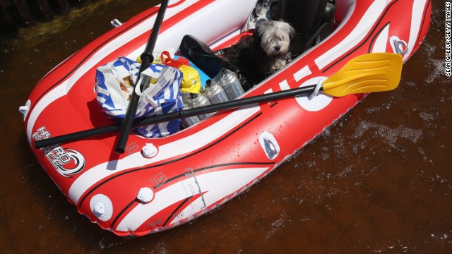 Chewbaca sits among groceries and bottles of butane in a rubber raft as his owner pulls him through a flooded street near the swollen Elbe River on June 7.
