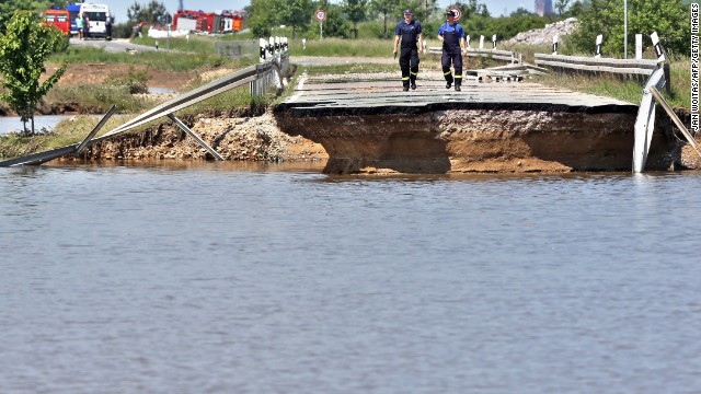 Members of the emergency services inspect a road washed away by flood water near Loebnitz, eastern Germany, on June 7.