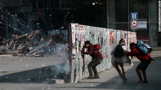 Protesters take cover behind a barricade as fireworks go off nearby on June 11.