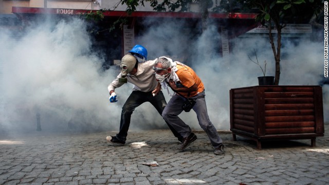 Protesters try to run from riot police on June 11.