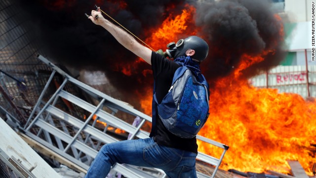 A protester uses a slingshot to throw stones at riot police on June 11.