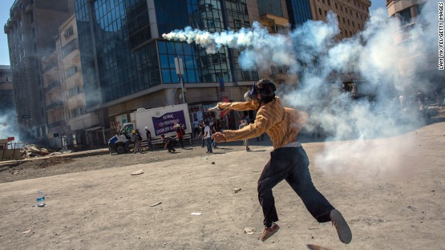 A protester throws a tear gas canister back toward police on June 11.