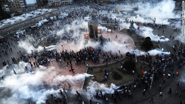 People flee as riot police fire tear gas on Taksim Square on June 11.