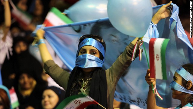 A supporter of Iranian presidential candidate Mohsen Rezaei, Iran's top commander during the war with Iraq, holds a blue flag bearing his portrait during a rally in Tehran on June 10.