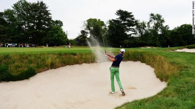 Roger Tambellini of the United States hits his second shot from a bunker on the first hole on June 13.