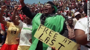 Jubilant residents of Soweto wait to hear newly freed Nelson Mandela speak at Orlando stadium February 12,1990. I\n