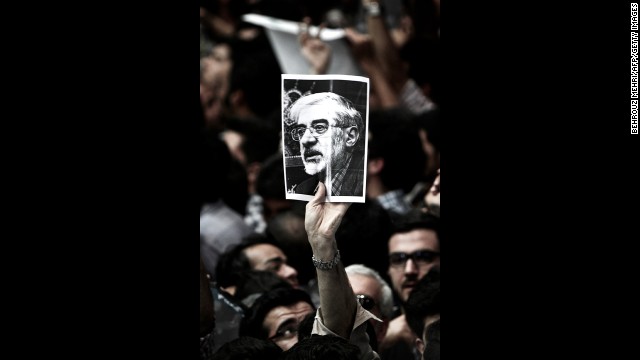 A man holds a portrait of opposition leader Mir Hossein Mousavi, who has been under house arrest since February 2011, during a campaign rally for Aref in Tehran on June 10.