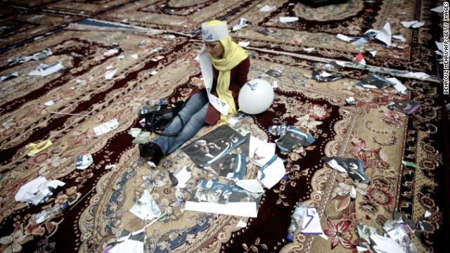 An Aref supporter checks her mobile phone surrounded by campaign posters after the June 10 rally in Tehran.