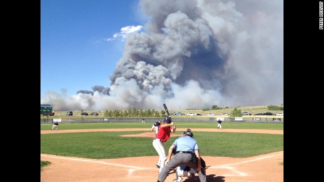 A baseball game goes on despite a raging wildfire in Colorado on Wednesday, June 12.