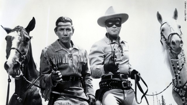 The Lone Ranger, played by Clayton Moore, right, and his Native American partner, Tonto, played by Jay Silverheels, pose with their trusty steeds.