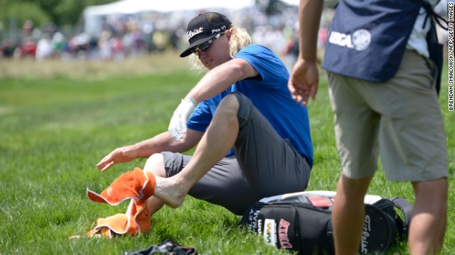 Charley Hoffman dries his feet after chipping to the fourth green from a creek during the third round on June 15. 