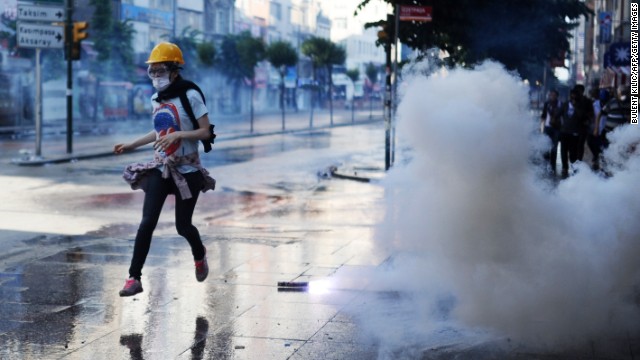 A protester runs during clashes between riot police and demonstrators in the streets adjacent to Taksim Square in Istanbul on Sunday, June 16. 