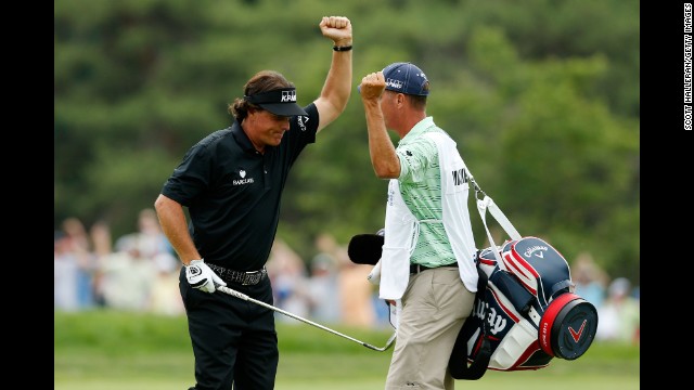 Phil Mickelson celebrates with caddie Jim Mackay after making a shot for eagle on the 10th hole par 4 during the final round on June 16.