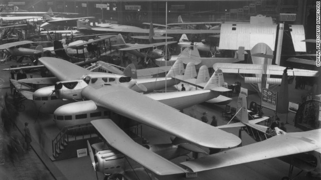 A Bleriot XII is displayed under a Bleriot 125 at the 1930 Paris Airshow. In the foreground, you can see a SPAD 91 biplane. 