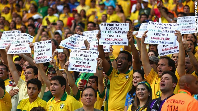 Fans hold up banners - which state that they are protesting against corruption, rather than the national team - ahead of Brazil's 2-0 win over Mexico.