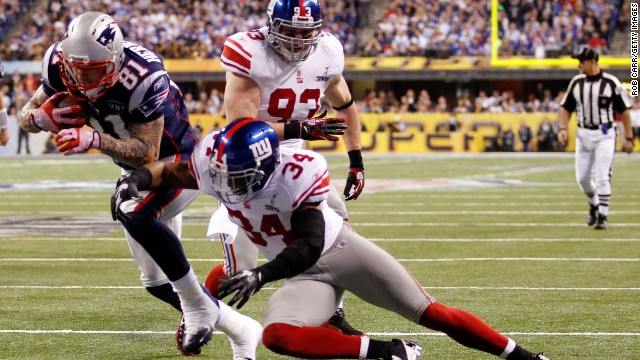 Hernandez runs for a 12-yard touchdown past Deon Grant of the New York Giants in the third quarter of Super Bowl XLVI on February 5, 2012, in Indianapolis.