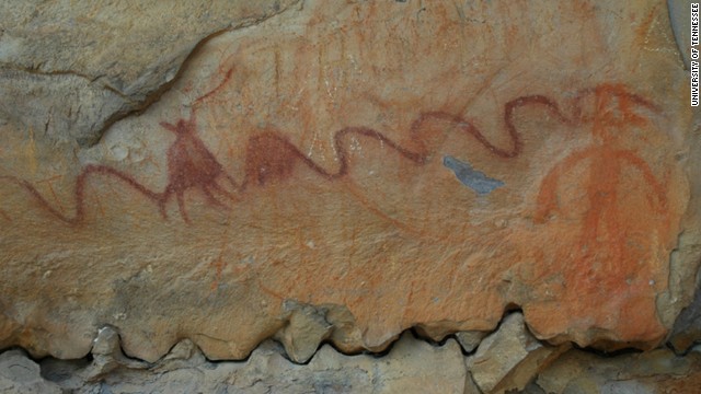 An ancient Native American pictograph found on a rock in northern Alabama features a long curving line and a faded circle behind. 