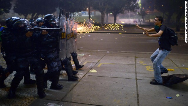 Police fire rubber bullets at a protester during clashes in Rio de Janeiro on Thursday, June 20. Demonstrations in Brazil began in response to <a href='http://www.cnn.com/2013/06/20/world/americas/brazil-protests/?hpt=hp_t2'>plans to increase fares for the public transportation system</a> but have broadened into wider protests over economic and social issues. Since then, both Sao Paulo and Rio de Janeiro have agreed to roll back prices on bus and metro tickets.<!-- -->
</br>