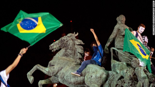 Demonstrators stand on a statue in Niteroi outside Rio de Janeiro on Wednesday, June 19.