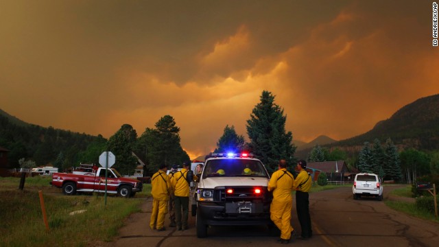 Firefighters monitor a wildfire in a residential area in South Fork on Friday, June 21.