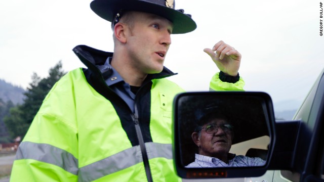 Colorado State Patrol Officer Jessie Bartunek speaks to a resident on the outskirts of South Fork on June 22.