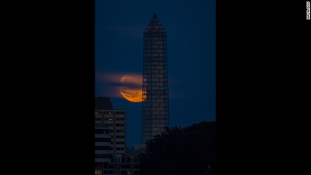 The moon rises behind the Washington Monument on June 23.