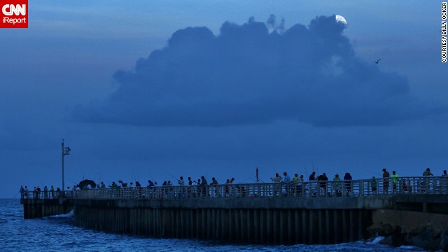 <a href='http://ireport.cnn.com/docs/DOC-993604'>Billy Ocker</a> stood on the pier of the Sebastian, Florida, inlet, photographing the supermoon peeking through the thick clouds overhead. "The moon was late in its showing and I almost thought I might not be able to see it because of the clouds. But just when I was about to give up, the Sun went completely down and I could see the clouds starting to glow white and then the Supermoon," he said.