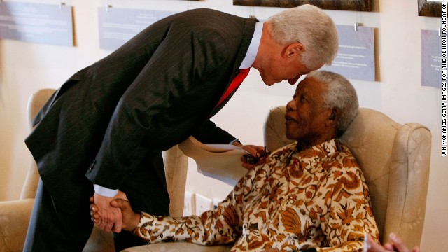 Former U.S. President Bill Clinton leans down to whisper to former South African President Nelson Mandela during a visit to the Nelson Mandela Foundation on July 19, 2007, in Johannesburg.