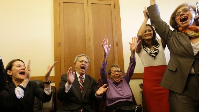 San Francisco Mayor Ed Lee, second from left, and Phyllis Lyon, center, celebrate at the mayor's office in San Francisco.