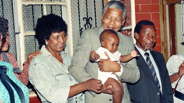 Nelson Mandela and his then-wife, Winnie, play with their grandchild Bambatha at their Soweto home in 1990.