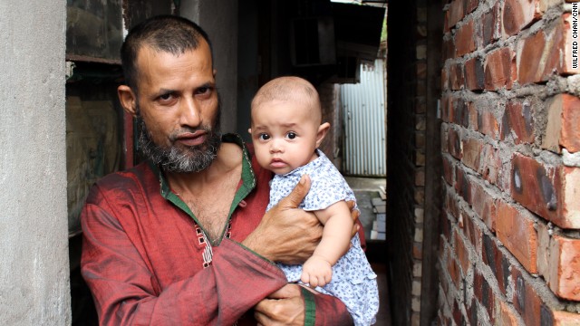 Mojibor, a 42-year old refugee from Bangladesh, holds his four-month old child in the village of Ping Che, Hong Kong on June 25, 2013. Mojibor and other asylum seekers in Hong Kong are legally forbidden to work, and dwell for years in decrepit housing on meager aid while awaiting a determination on their refugee status.