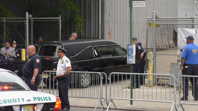 A hearse pulls up near a side entrance to the church.