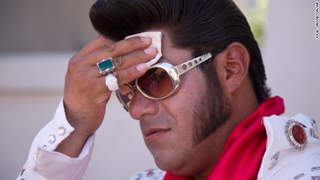 Elvis impersonator Cristian Morales wipes sweat from his brow while posing for photos with tourists on the Las Vegas Strip on Thursday, June 27.