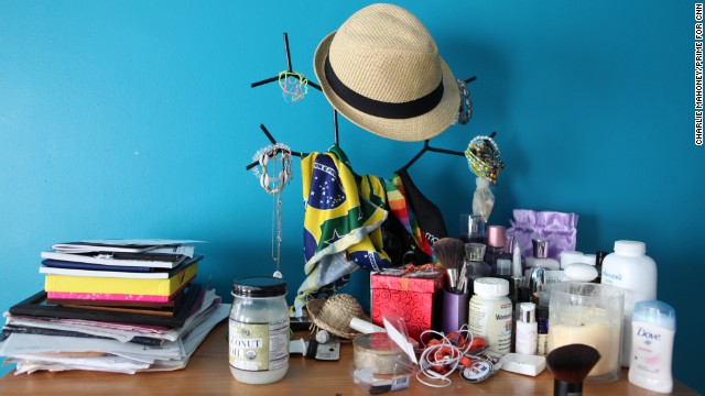 Personal items, make-up and a bandera of the flag of Brazil adorn a dresser in Renata's apartment in Boston.