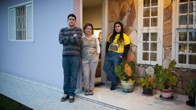 Renata would have to wait five years before she can begin petitioning for her family's return to the United States, but the process could take as long as seven years if an upcoming amendment passes that would further militarize the border. Here her brother, mother and sister pose outside their home in Brazil.