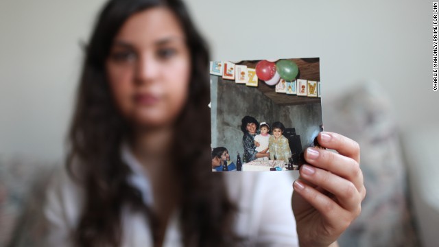 Renata shows a photo of her with her brother and mother during a birthday party prior to her arrival in the United States.