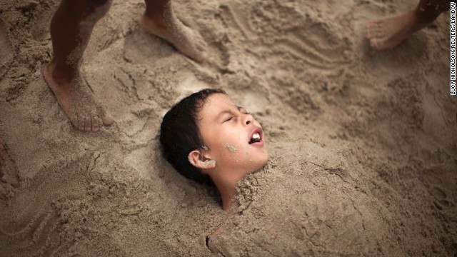 R.J. Hernandez, 8, of El Campo, Texas, is buried in sand as he tries to stay cool in Santa Monica on June 28.