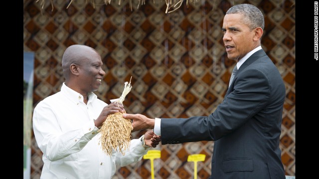 Obama shows the White House press corps what rice looks like before it's threshed on June 28 in Dakar.