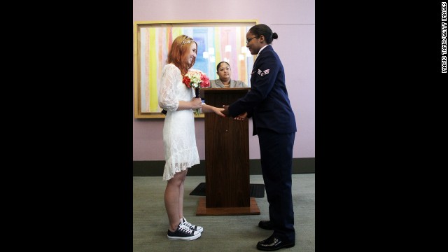 U.S. Air Force Senior Airman Shyla Smith, right, and Courtney Burdeshaw hold hands in the west chapel during their wedding ceremony at the Manhattan Marriage Bureau on Thursday, June 27.