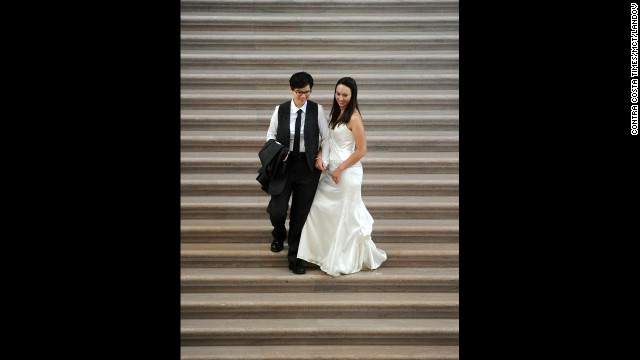 Diane Meier, left, and Julie Thompson walk down the grand staircase at San Francisco City Hall after getting married on June 29.