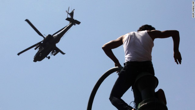 A protester watches an Apache helicopter as it flies over Tahrir Square on June 30. Morsy's opponents stood their ground in the square, where protests two years ago helped topple Hosni Mubarak's 29-year rule.