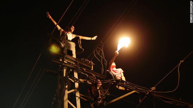 Protesters sit on top of a power pole as they chant slogans against Morsy outside the presidential palace in Cairo on June 30. "Egypt is on the brink of a volcano," government-run newspaper Al-Akhbar said.