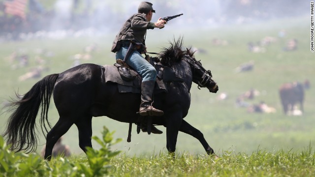 A Confederate Civil War cavalry reenactor shoots at Union soldiers during Pickett's Charge on the last day of a Battle of Gettysburg reenactment on Sunday, June 30, during 150th anniversary celebrations in Gettysburg, Pennsylvania. More than 10,000 reenactors will pay tribute to the major clashes that took place in the pivotal Civil War battle in July 1863.