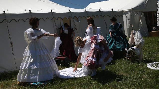 Women remove Civil War-era dresses while participating in the event on June 29. 