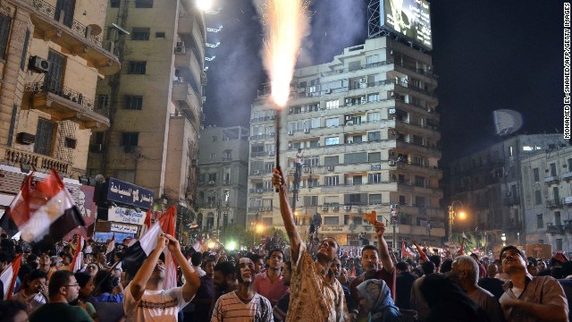 A protester lights a flare as hundreds of thousands of demonstrators gather in Cairo's landmark Tahrir Square on July 1 during a protest calling for the ouster of Morsy.