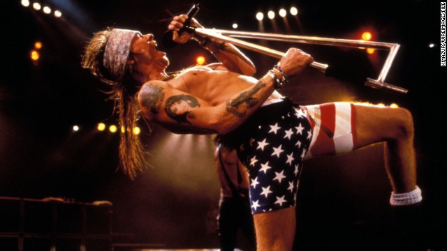 Axl Rose rocks out in flag biker shorts at a '90s Guns 'N Roses show.