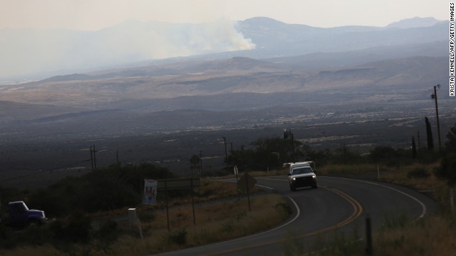 Smoke from the Yarnell Hill Fire is visible from a distance on a road to Yarnell, Arizona, on Monday, July 1. The wildfire started Friday, June 28, near Yarnell, apparently because of lightning strikes. Extreme heat is hindering efforts to stop the fire, which has scorched more than 8,400 acres. Nineteen firefighters were killed on Sunday, June 30, battling the blaze.